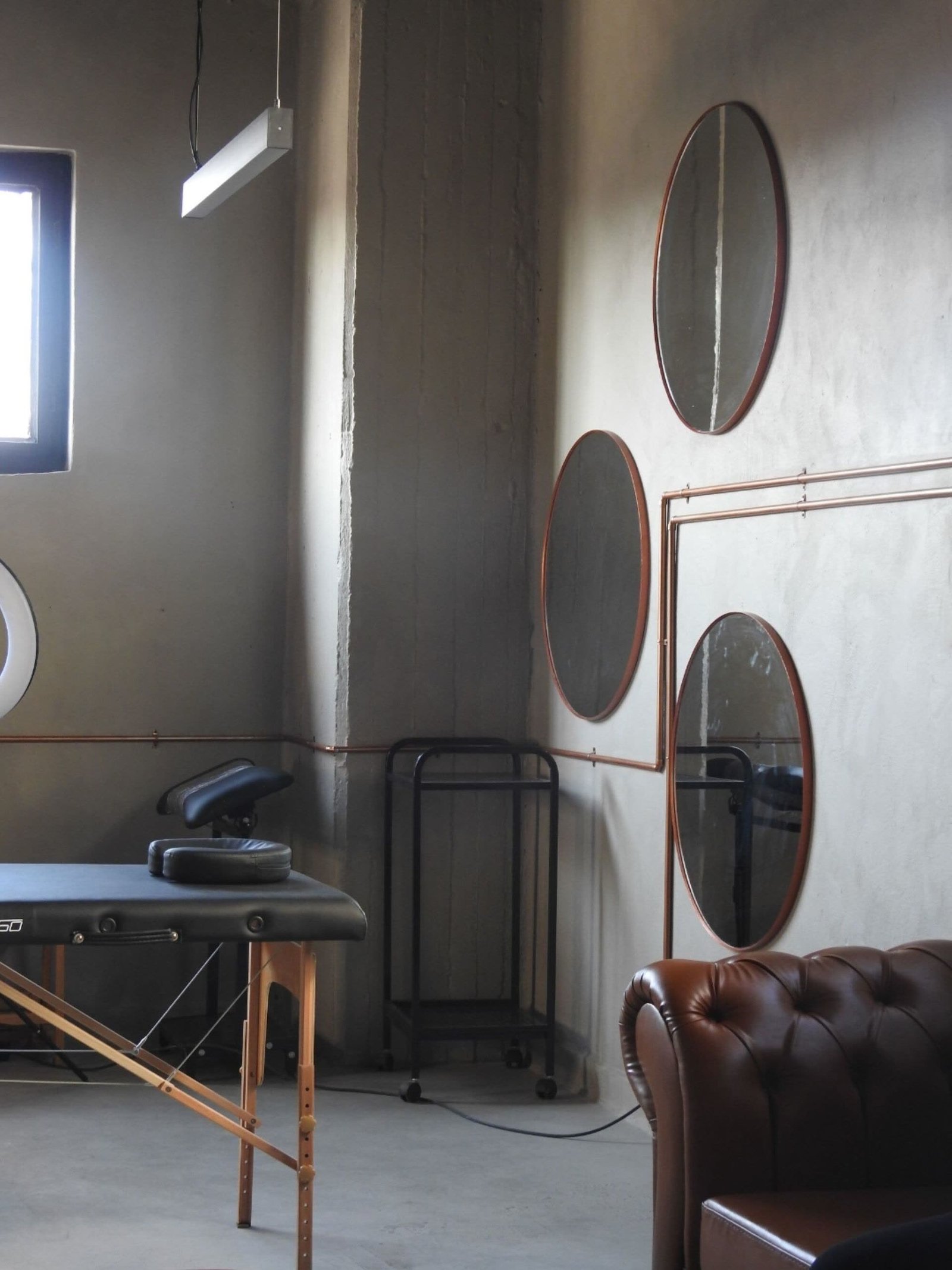 Minimalist private studio suite with styling chair and mirrors